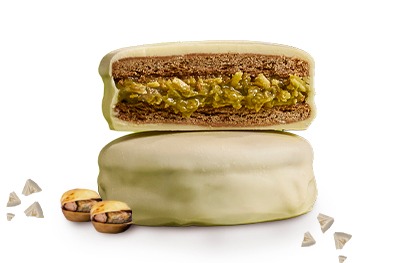 Alfajor-white-dubai Alfajor white dubai cortado al medio dejando ver el relleno de pistacchio.